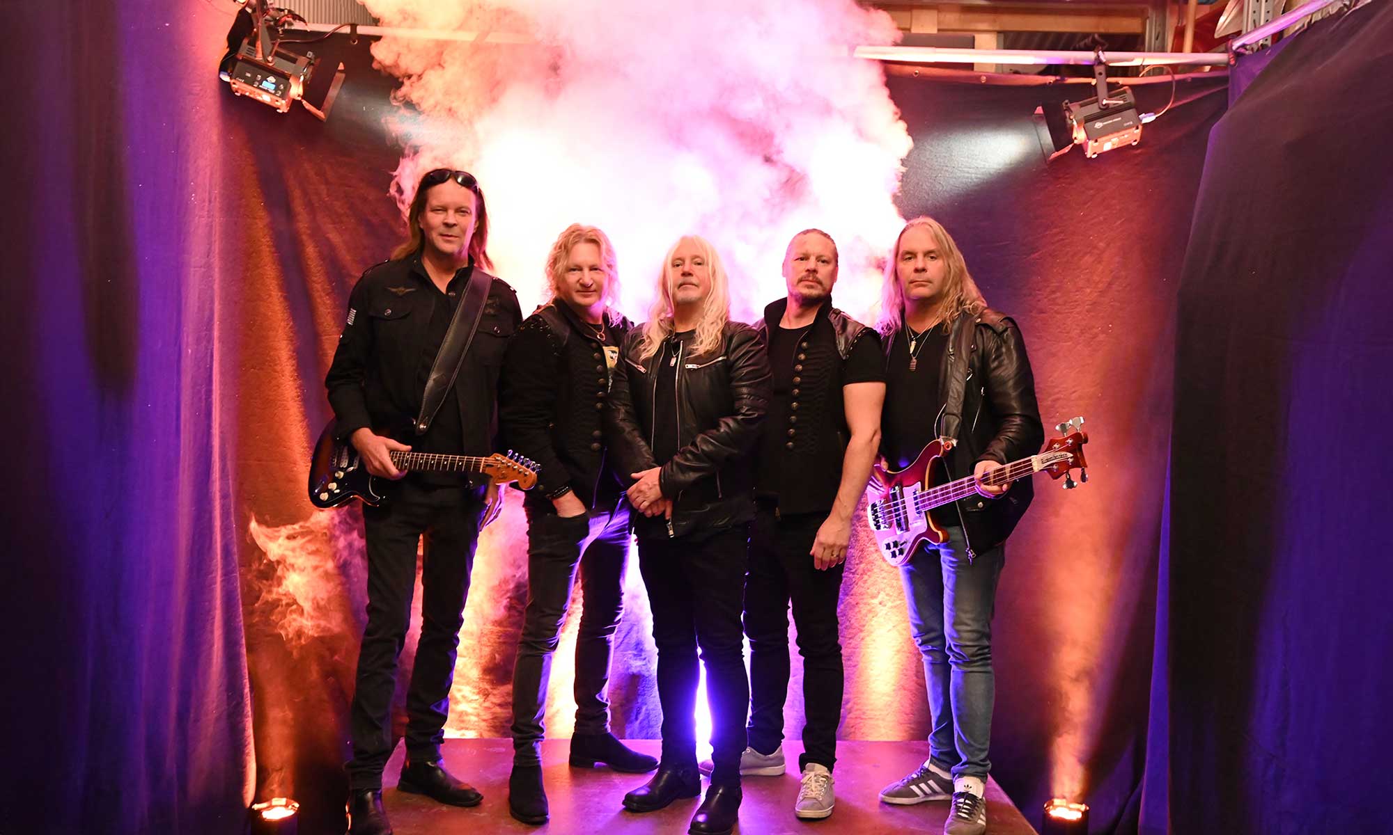 Gruppbild på fem personer som står på en scen